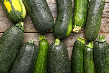 Fresh zucchini squashes on wooden background