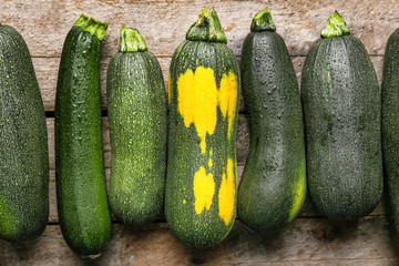 Fresh zucchini squashes on wooden background
