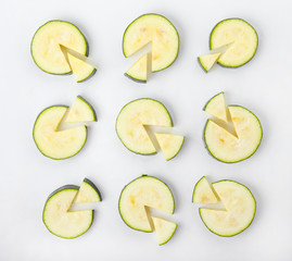 Slices of fresh zucchini squash on white background