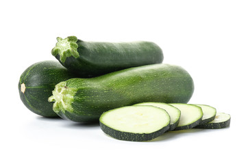 Fresh zucchini squashes with pieces on white background