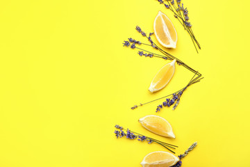 Beautiful lavender flowers with lemon pieces on color background