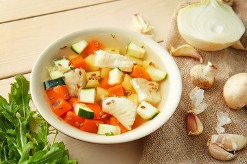 Bowl of tasty soup on wooden table
