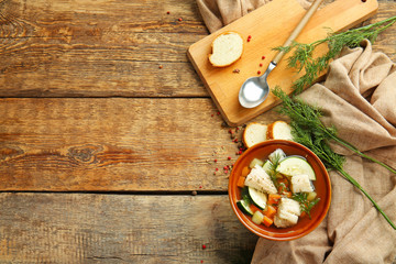 Bowl of tasty soup on wooden table