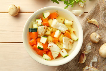 Bowl of tasty soup on wooden table