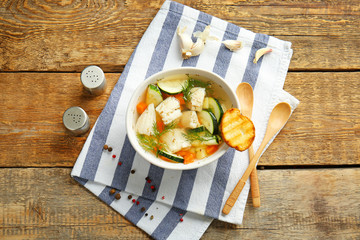 Bowl of tasty soup on wooden table