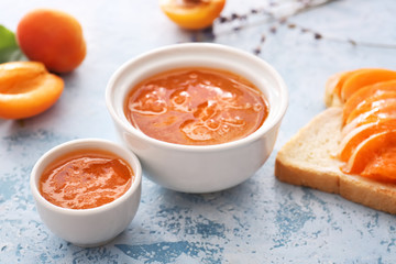 Bowls of tasty apricot jam on table