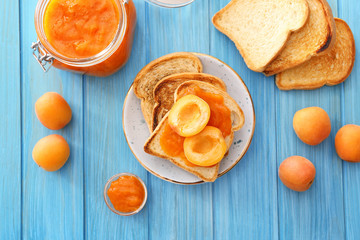 Bread slices of tasty apricot jam on wooden table