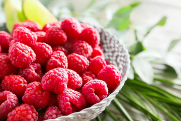 Bowl with fresh raspberries on table, closeup
