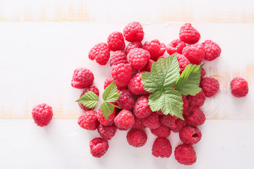 Heap of fresh raspberries on white wooden table