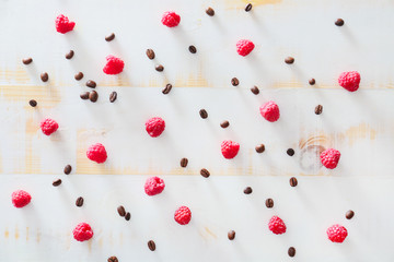 Fresh raspberries with coffee beans on light background