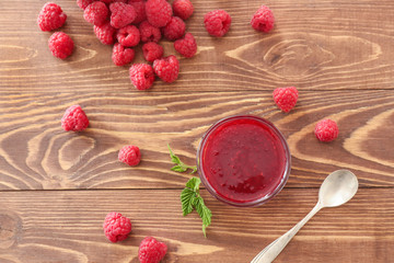 Tasty raspberry jam on wooden table
