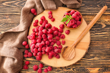 Board with fresh raspberries on wooden table