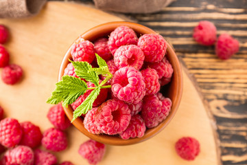 Bowl with fresh raspberries on table, closeup