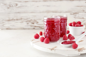 Tasty raspberry jam on white table