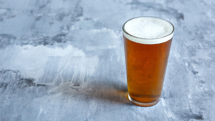 Glass of light beer on white stone background. Cold alcohol drink are prepared for a friend's party. Concept of drinks, fun, food, celebrating, meeting, oktoberfest.