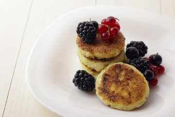 Cottage cheese pancakes or syrniki on plate, close up
