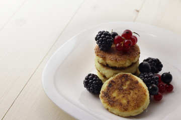 Cottage cheese pancakes or syrniki on plate, close up