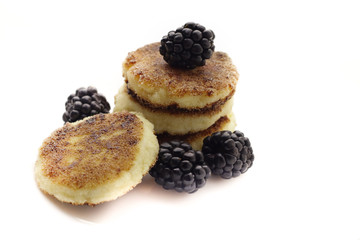 Cottage cheese pancakes or syrniki with fresh berries on plate, close up