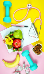 Healthy lifestyle prescription for good health concept flatlay with stethoscope, healthy food, and exercise equipment on modern pastel background.