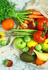 Healthy lifestyle shopping concept flatlay with colorful variety of fruit and vegetables on white marble table.