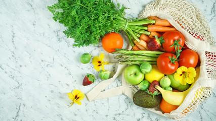 Healthy lifestyle shopping concept flatlay with colorful variety of fruit and vegetables on white marble table.