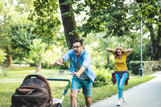 Worried Father And Mother Running After Their Baby In Stroller.