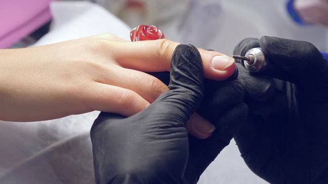 Manicure process. Correction of female nails with drilling machine