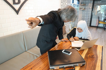 businessman muslim customer complaining muslim seller because of her work is too late with unhappy...