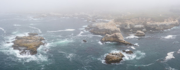 Seen from a bird's eye view, the Pacific Ocean washes against the rocky coast south of Monterey in Northern California. This beautiful area runs parallel to the famed Pacific Coast Highway.
