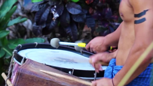 Polynesian men drumming shirtless in Hawaii