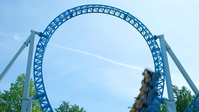 amusement park visitors ride circle on blue roller coaster