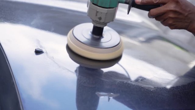 mechanics using car polishing machines for car paint finishing