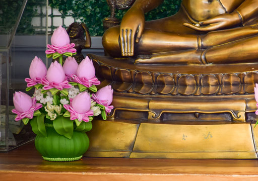 Close-up images of Buddha images and pink lotus flowers placed in the shrine. Faith and belief in Buddhism concept.