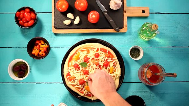 V&iacute;deo preparando pizza com igredientes frescos como molho de tomate, queijo mussarela, tomate cereja, piment&atilde;o e or&eacute;gano