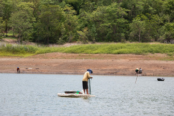 Villagers are searching for fish at Land with dry and cracked ground because dryness global warming,Global warming background