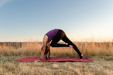 Active yogi girl stretching before practice outdoors 