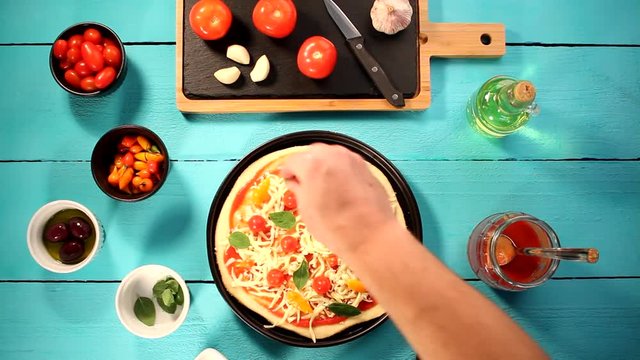 V&iacute;deo preparando pizza com igredientes frescos como molho de tomate, queijo mussarela, tomate cereja, piment&atilde;o e or&eacute;gano