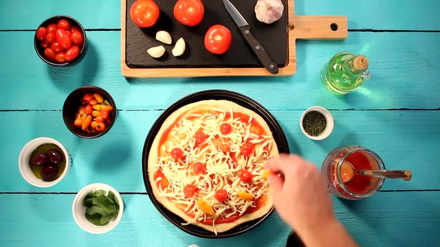 V&iacute;deo preparando pizza com igredientes frescos como molho de tomate, queijo mussarela, tomate cereja, piment&atilde;o e or&eacute;gano