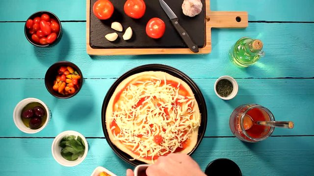 V&iacute;deo preparando pizza com igredientes frescos como molho de tomate, queijo mussarela, tomate cereja, piment&atilde;o e or&eacute;gano