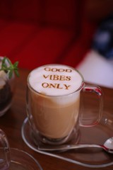 cup of coffee with cream on wooden background