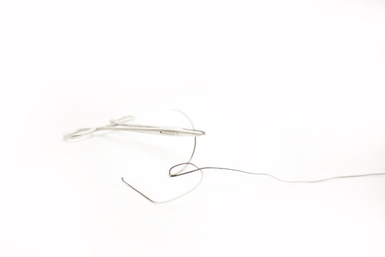 Forceps with curved suture needle isolated white background- Image