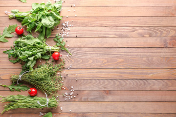 Different fresh herbs and spices on wooden background