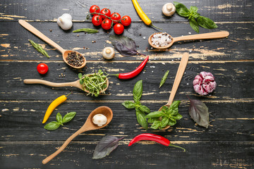 Different fresh herbs and spices on dark wooden background