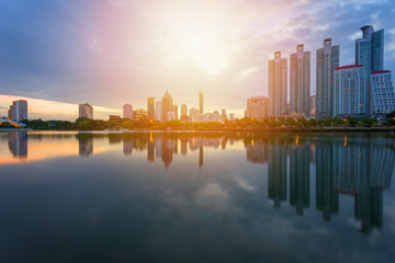 Fototapeta premium Budynek miasta z odbiciem wody przed zachodem słońca