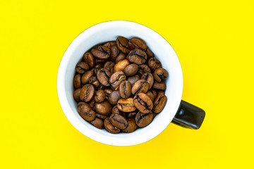 cup with coffee beans and colored paper background