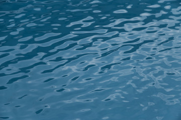 Blue swimming pool edge with refection of water ripple
