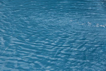 Blue swimming pool edge with refection of water ripple