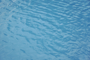 Blue swimming pool edge with refection of water ripple