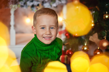 Fototapeta na wymiar boy in the Christmas lights bokeh