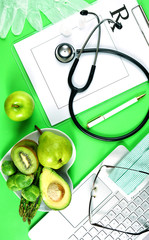 Prescription for good health overhead stop motion with doctor's desk, rx form, stethoscope, healthy fresh food on symbolic green background.